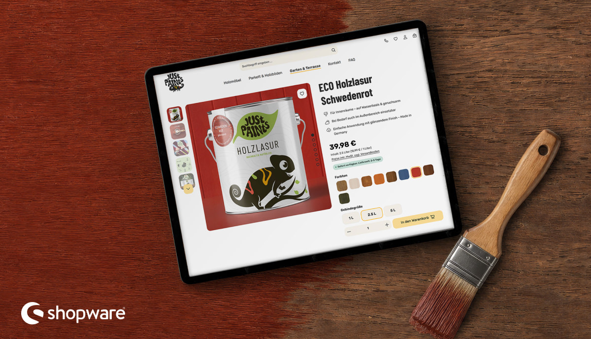 Shopware-6-Onlineshop von Just Paints mit ECO Holzlasur in Schwedenrot auf einem Tablet neben einem Pinsel.