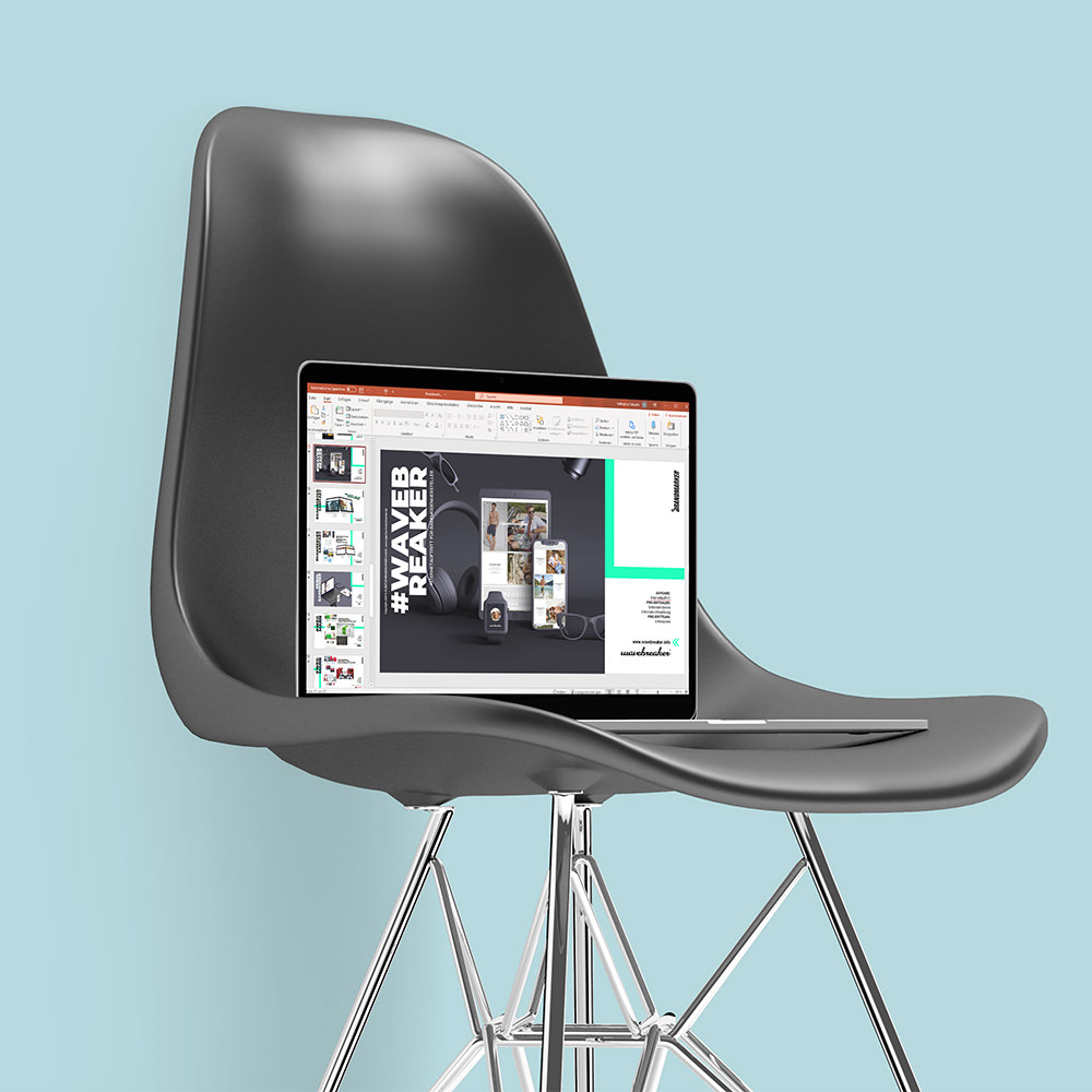 Aufgeklappter Laptop steht auf einem modernen Stuhl und zeigt eine Power Point Präsentation im Bearbeitungsmodus.