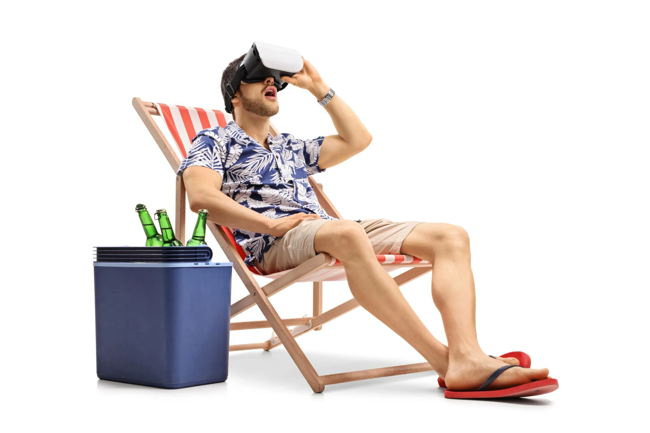 Ein Mann im Liegestuhl am Strand mit einer VR Brille auf