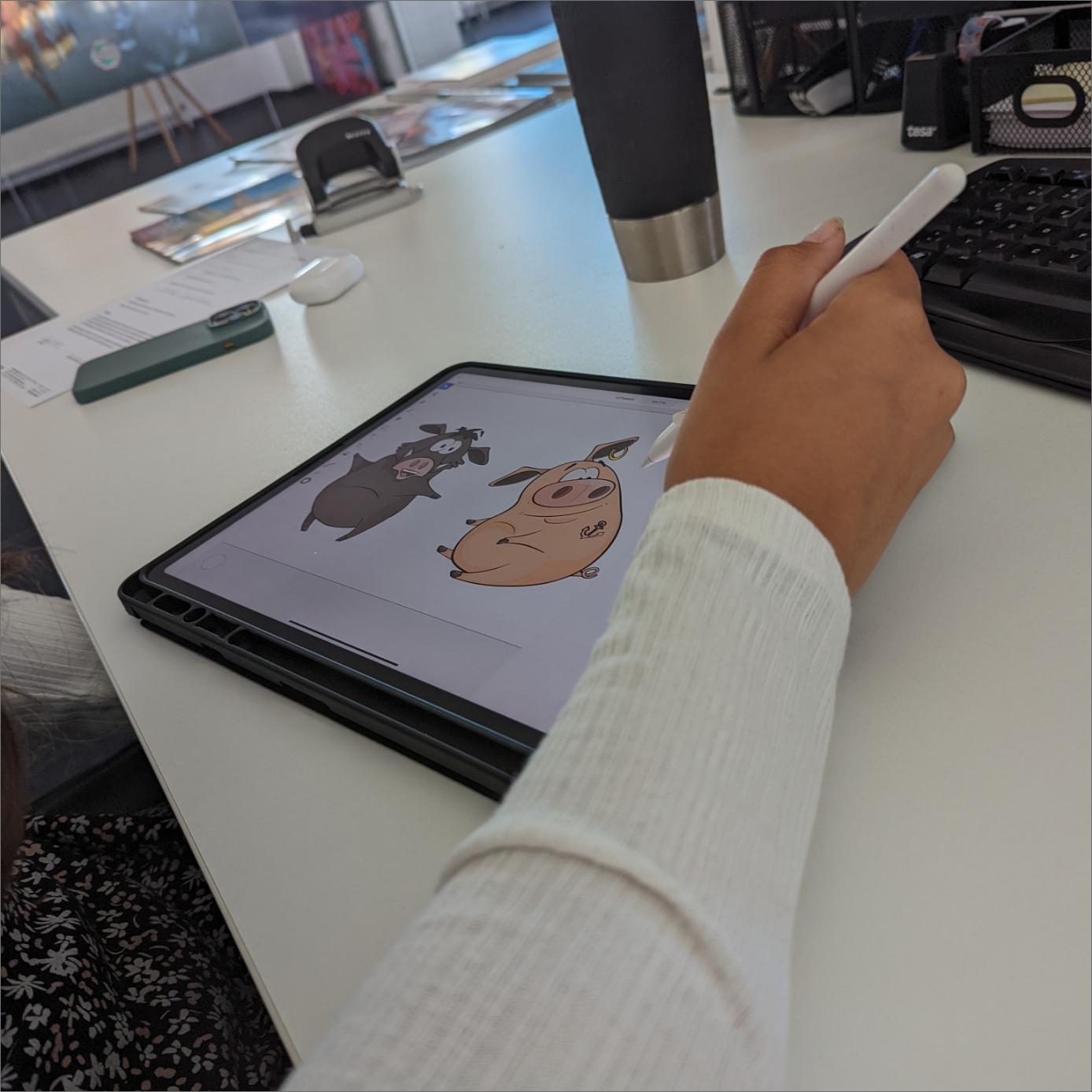 Detailausschnitt der Hand beim Zeichnen mit einem Wildschwein und Schwein auf dem Tablet